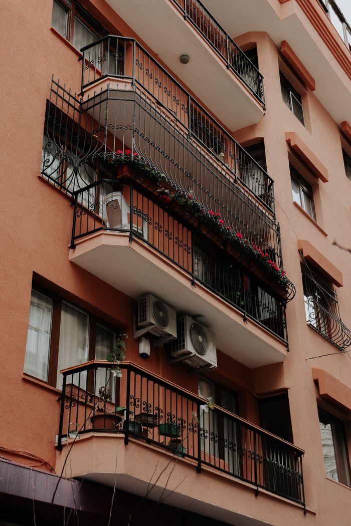 Close-up view of a residential building facade featuring balconies and air conditioning units, perfect for urban architecture themes.